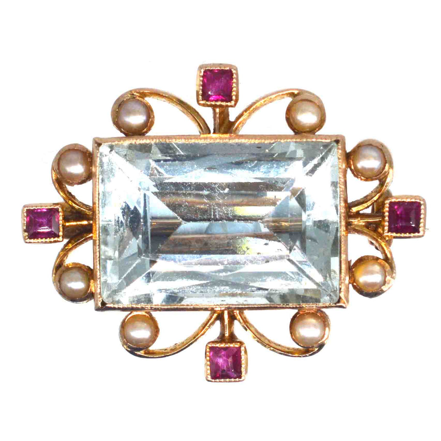 Edwardianische Brosche aus 18-karätigem Gold mit Aquamarin, Rubin und Perle in einem wirbelnden Vintage-Design.