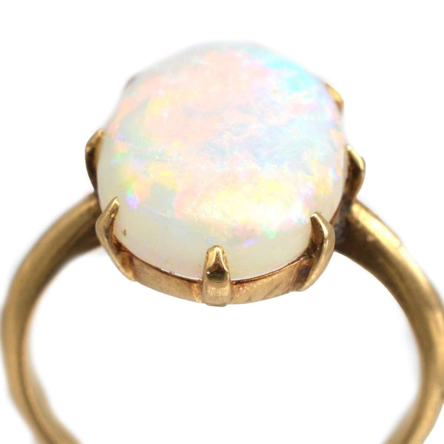 Ring aus 18-karätigem Gold im Art-Déco-Stil mit einem leuchtenden weißen Opal, der in den Farben Rot, Grün und Blau aufblitzt.