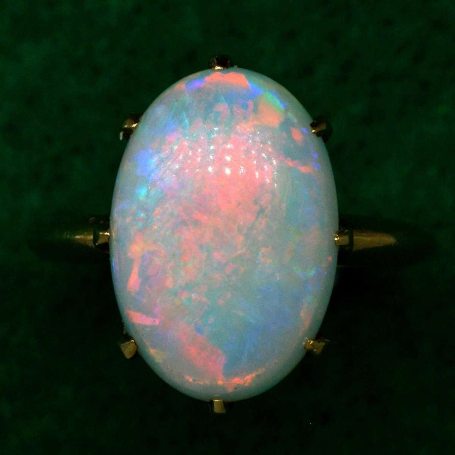 Ring aus 18-karätigem Gold im Art-Déco-Stil mit einem leuchtenden Opal, der in den Farben Rot, Grün, Blau und Gelb leuchtet.