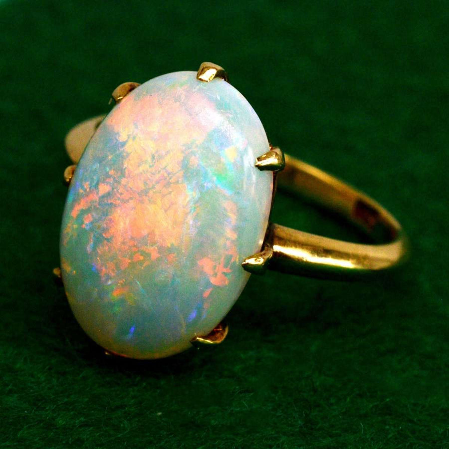 Opalring aus 18-karätigem Gold im Art-Déco-Stil mit lebhaften roten, blauen und grünen Farben und einem schillernden weißen Opal in der Mitte.