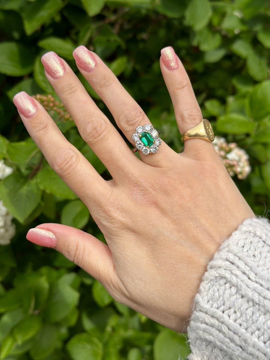 Art-Deco-Ring aus 18 Karat Gold und Platin mit einem kolumbianischen Smaragd und Diamanten, getragen an einer Hand.