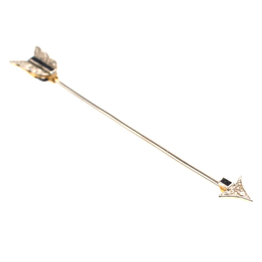 Art Deco platinum and gold arrow brooch with black sapphire and diamonds, vintage 1920s design.
