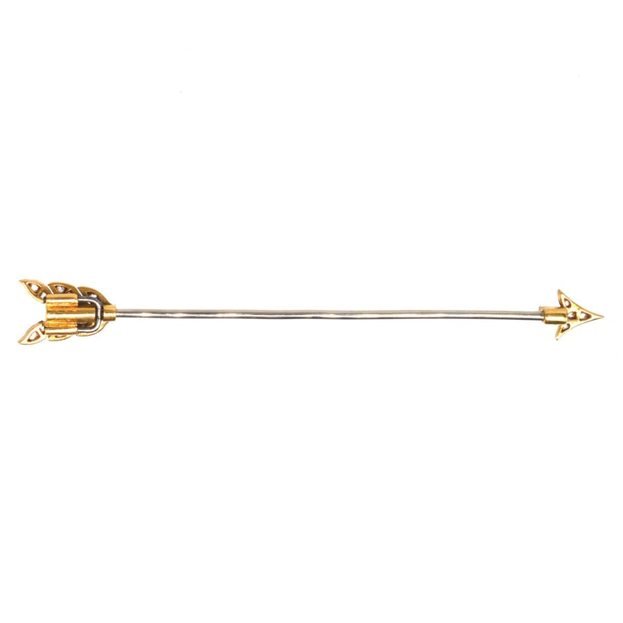 Art Deco platinum and 18ct gold arrow brooch featuring black sapphire and diamond accents, vintage 1920s jewelry.