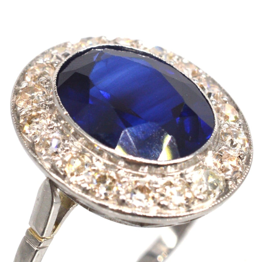Platinring im Art-Déco-Stil mit einem ovalen synthetischen Saphir, der von Diamanten umgeben ist, die eine exquisite Handwerkskunst darstellen.