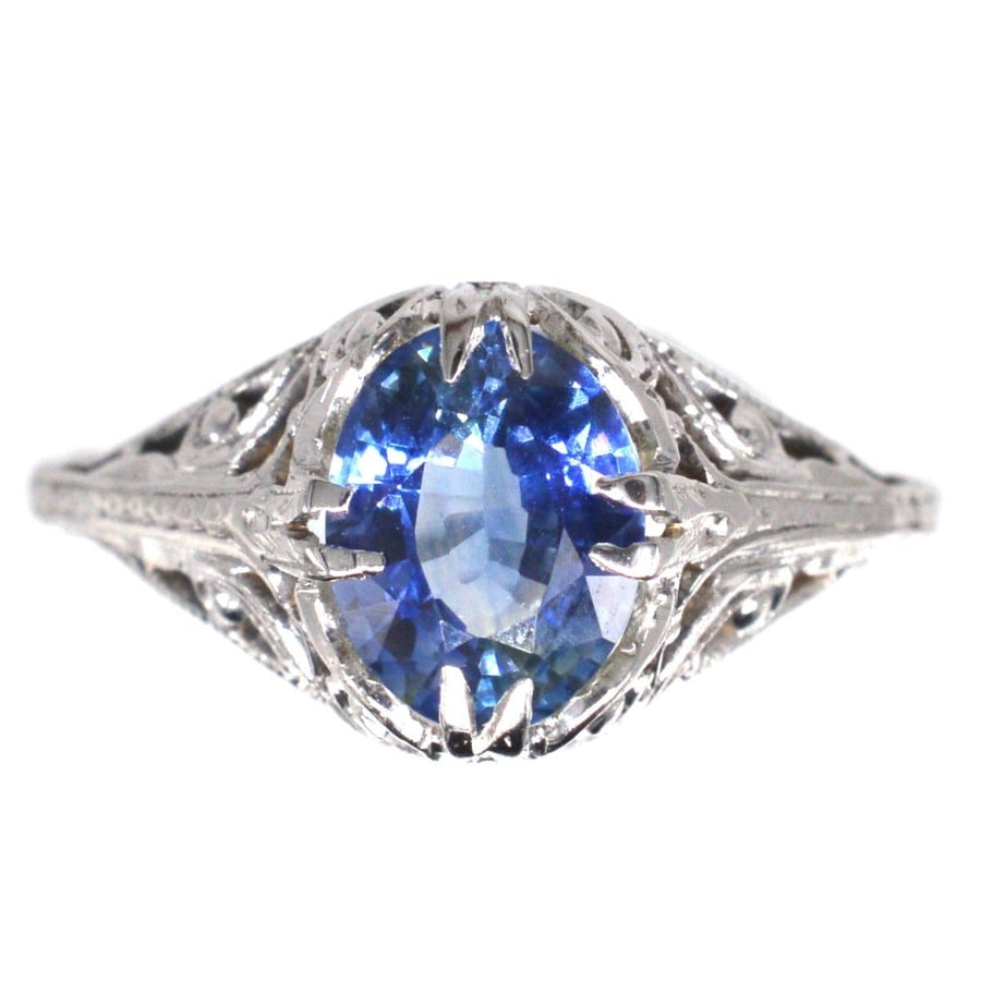 Belle-Epoque-Ring aus 18 Karat Weißgold mit einem kornblumenblauen Saphir in einem verschlungenen Blattmuster.