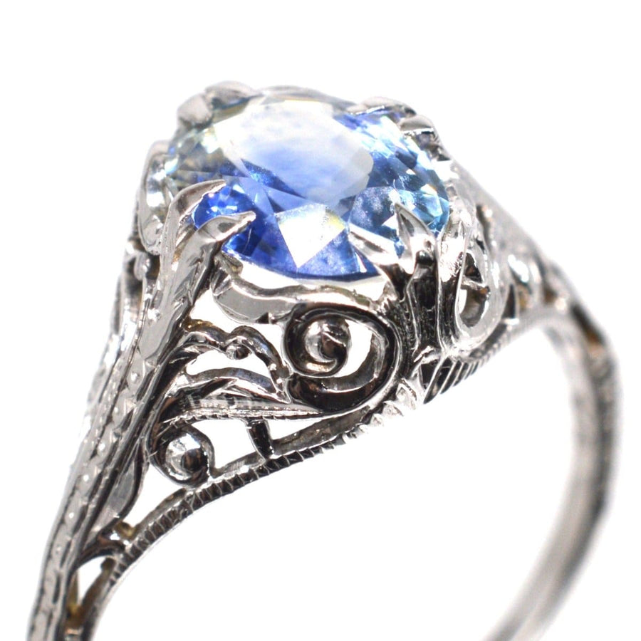 Belle-Epoque-Ring aus 18 Karat Weißgold mit einem kornblumenblauen Saphir und einem verschlungenen Blattwerk.