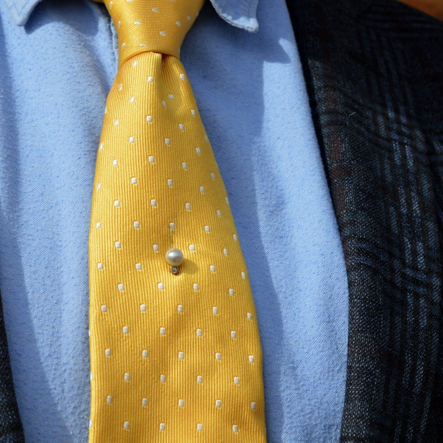 Elegant Edwardian 14ct gold natural pearl and diamond tie pin on a yellow polka dot silk tie.