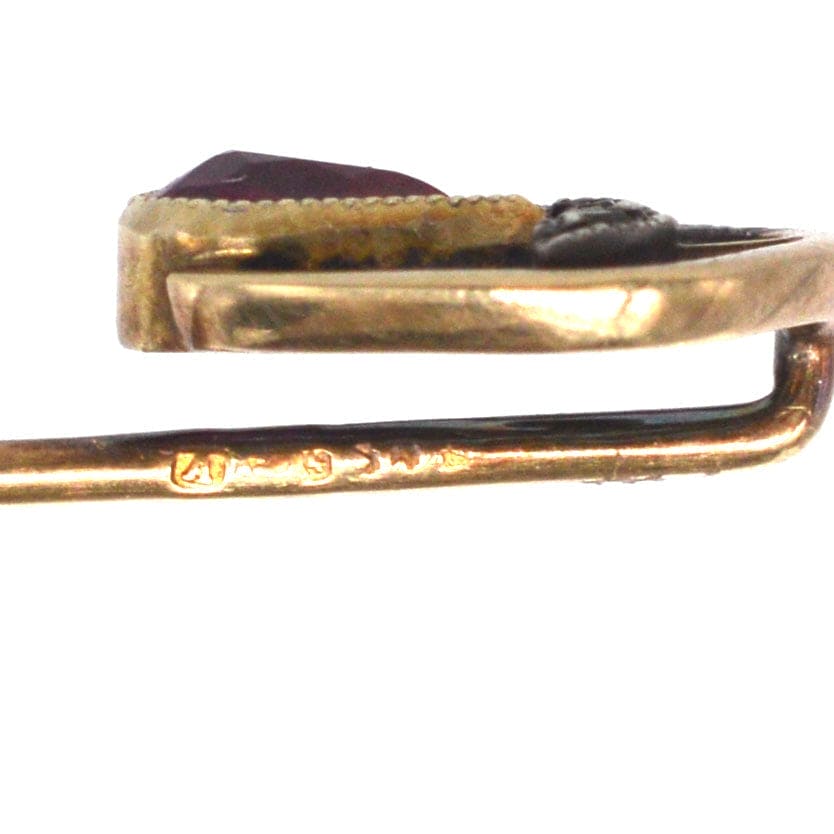 Nahaufnahme einer edwardianischen Krawattennadel aus 14-karätigem Gold mit synthetischem rotem Spinell und Diamantverzierung.