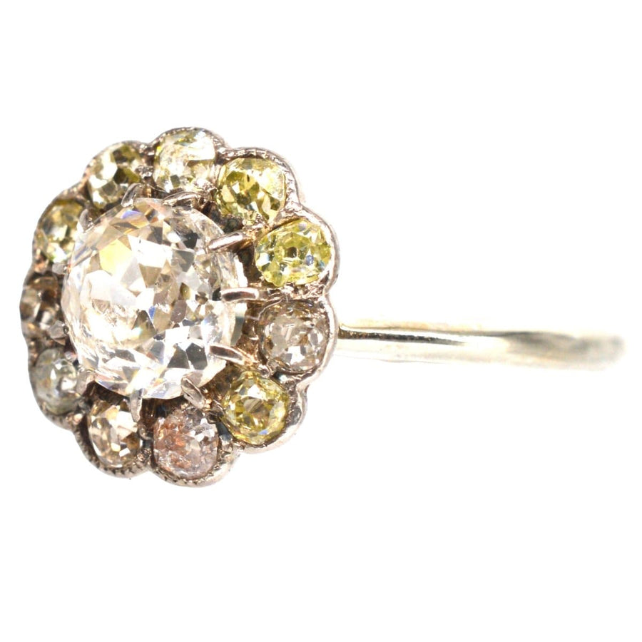 Edwardian 18ct white gold diamond cluster ring with old mine cut center and tinted diamonds.