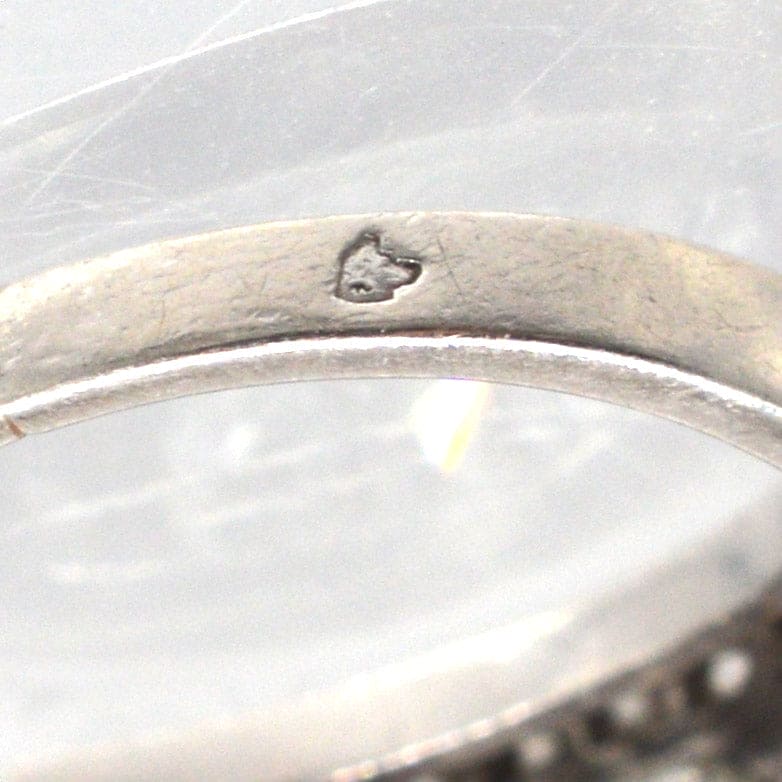 Nahaufnahme des Innenrings eines französischen Art-Déco-Platinrings mit Punzierung und feinen Details.
