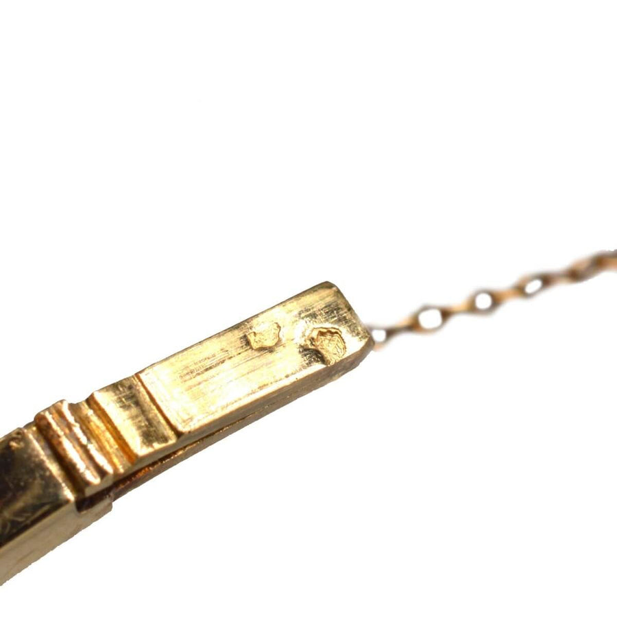 Nahaufnahme des Verschlusses eines alten Goldschmuckstücks mit komplizierten Details.
