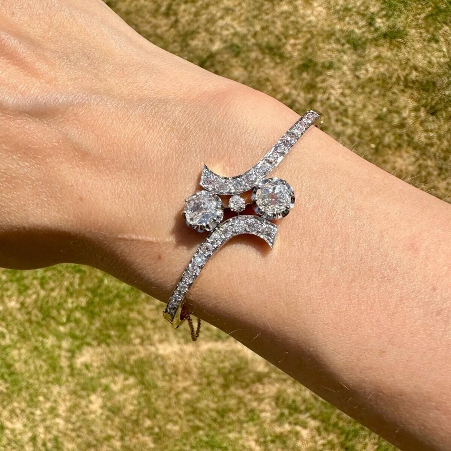Französischer Diamantarmreif aus 18 Karat Gold und Platin Toi et Moi am Handgelenk im Sonnenlicht.