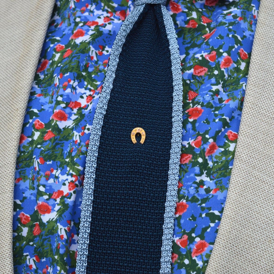 Spätviktorianische Krawattennadel aus 9-karätigem Gold mit Hufeisen auf einem blumengemusterten Hemd, das Glück und Hingabe symbolisiert.