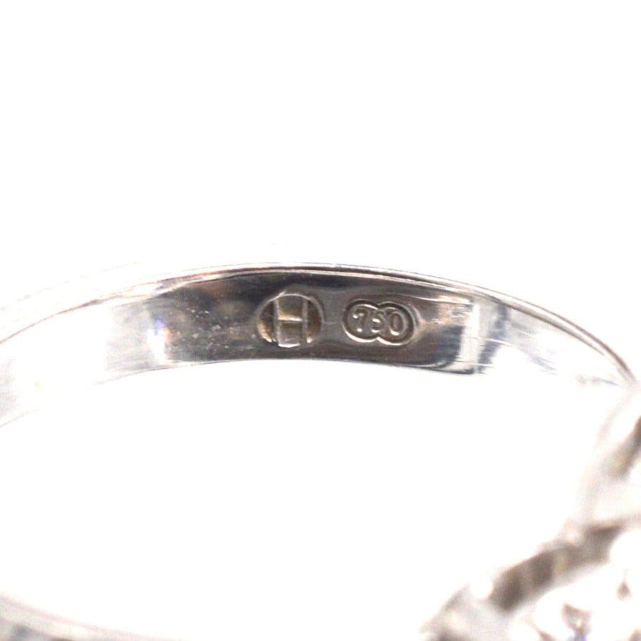 Nahaufnahme des Innenrings eines modernen Dreistein-Diamant-Clusterrings mit 750er-Punze.