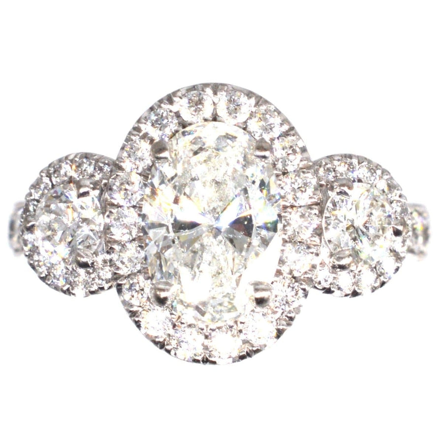Moderner Dreistein-Diamantenring mit einem zentralen Diamanten von 1,51 Karat und exquisitem Halo-Design.