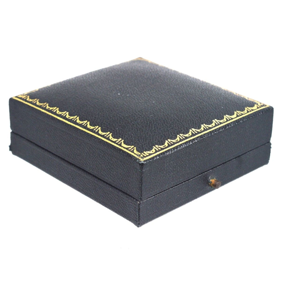 Black leather jewellery box with gold decorative trim for vintage earrings.