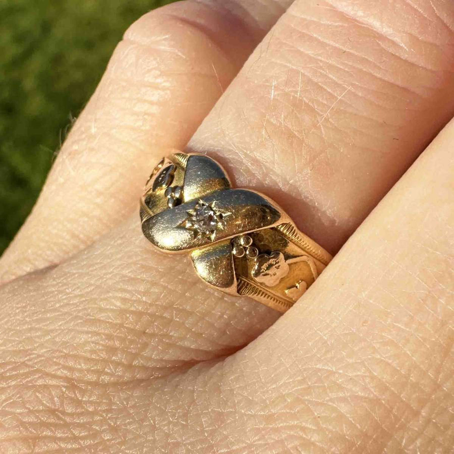 Viktorianischer Kussring aus 18-karätigem Gold und Diamanten mit floralen Details und "X"-Design, das Liebe und Neuanfang symbolisiert.