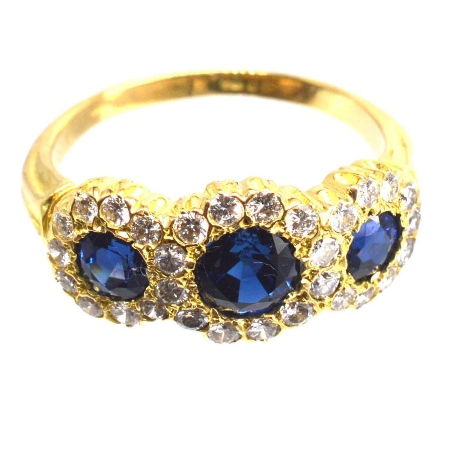 Vintage 18ct gold ring featuring sapphire and diamond triple cluster design, perfect for engagements or special occasions.
