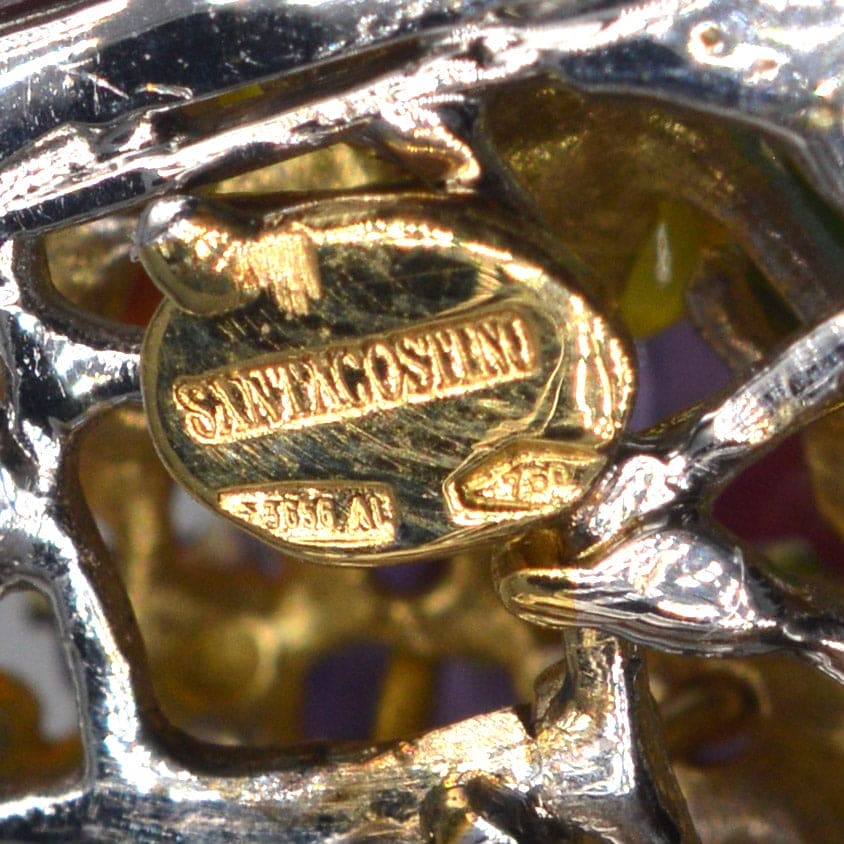Close-up of vintage Santagostino brooch signature tag and hallmarks on 18ct white gold.