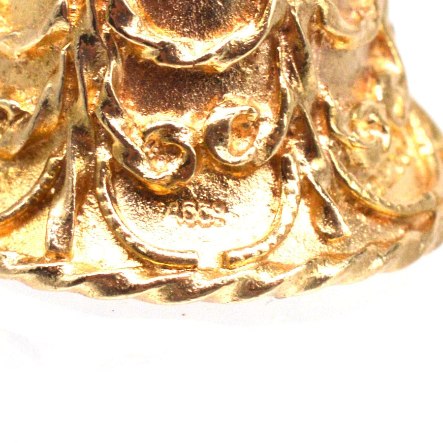 Nahaufnahme eines Vintage-Anhängers aus 9-karätigem Gold mit Glockencharme, der aufwändige Details in Form von Schnörkeln und Schnörkeln zeigt.