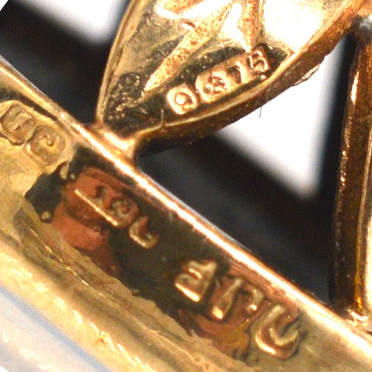 Nahaufnahme der Punzierung eines Anhängers aus 9-karätigem Gold aus den 1940er Jahren, der handwerkliches Können und Qualität demonstriert.