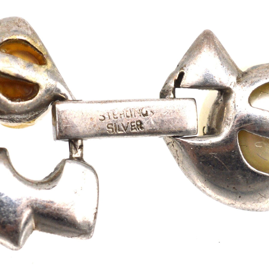 Nahaufnahme eines Armbands aus Sterlingsilber im Retro-Stil der 1940er Jahre mit gelben Akzenten und Verschlussdetails.