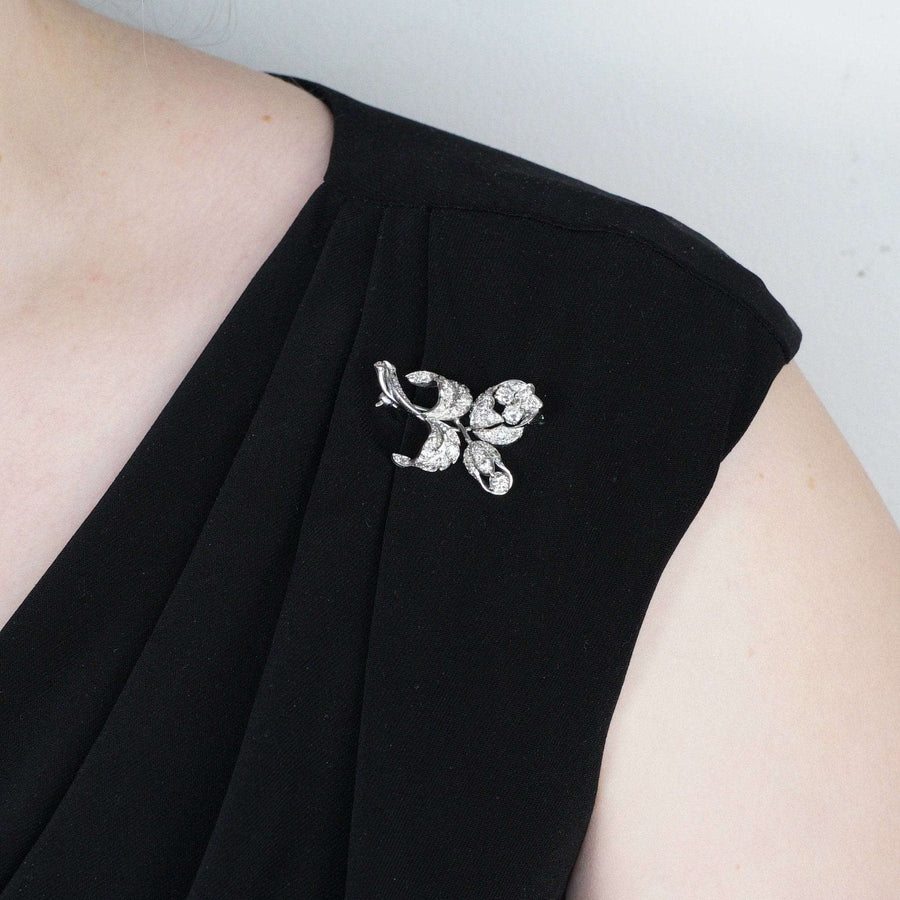 Diamantbrosche aus 18-karätigem Weißgold aus den 1950er Jahren, die an einem schwarzen Kleid getragen wird und exquisite Handwerkskunst zeigt.
