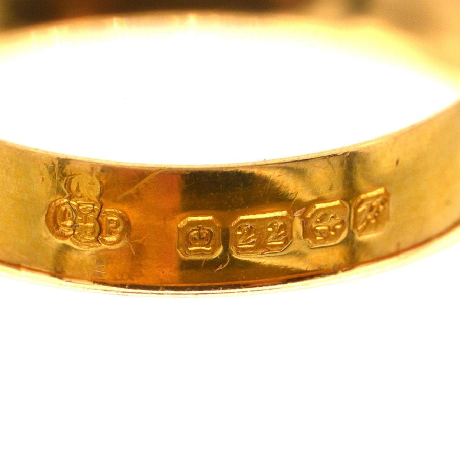 Nahaufnahme eines Eherings aus 22-karätigem Gold aus den 1950er Jahren, der die Herstellermarken von Birmingham und die butterweiche Goldoberfläche zeigt.