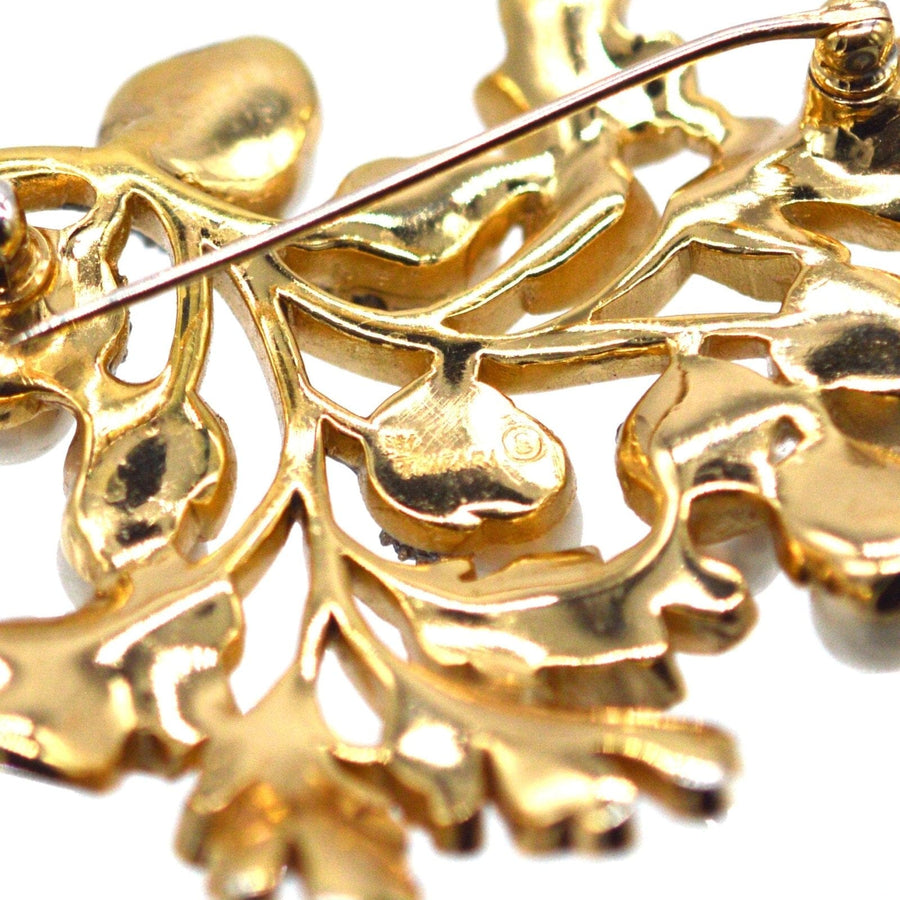 Detaillierte Nahaufnahme des goldfarbenen Eichenblattmusters von Trifari, das Handwerkskunst und Vintage-Stil zeigt.