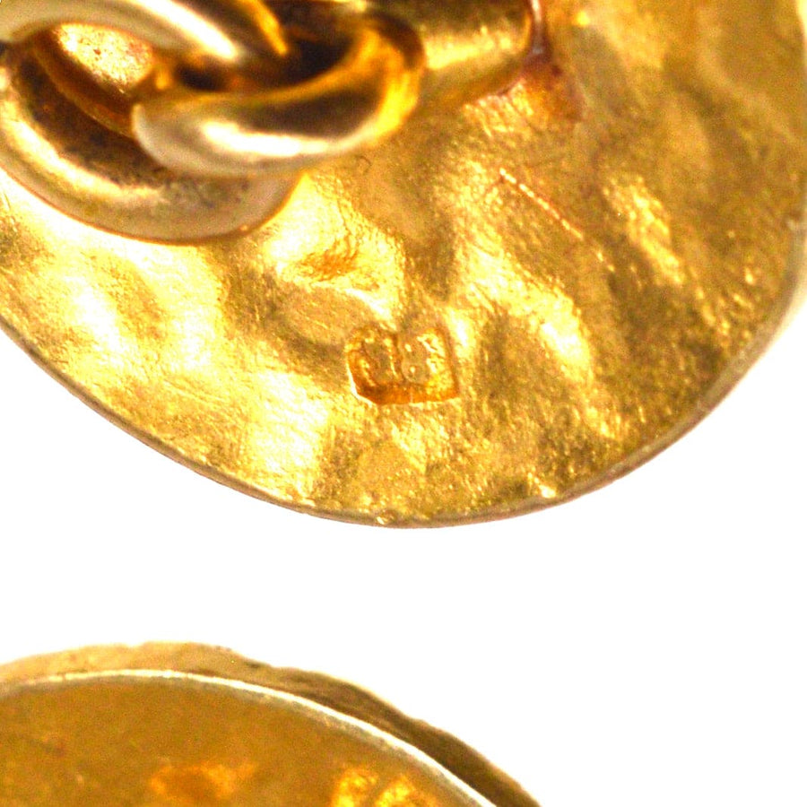 Nahaufnahme von Manschettenknöpfen aus 18-karätigem Gold aus den 1960er Jahren mit strukturierter Oberfläche und Punzierung.