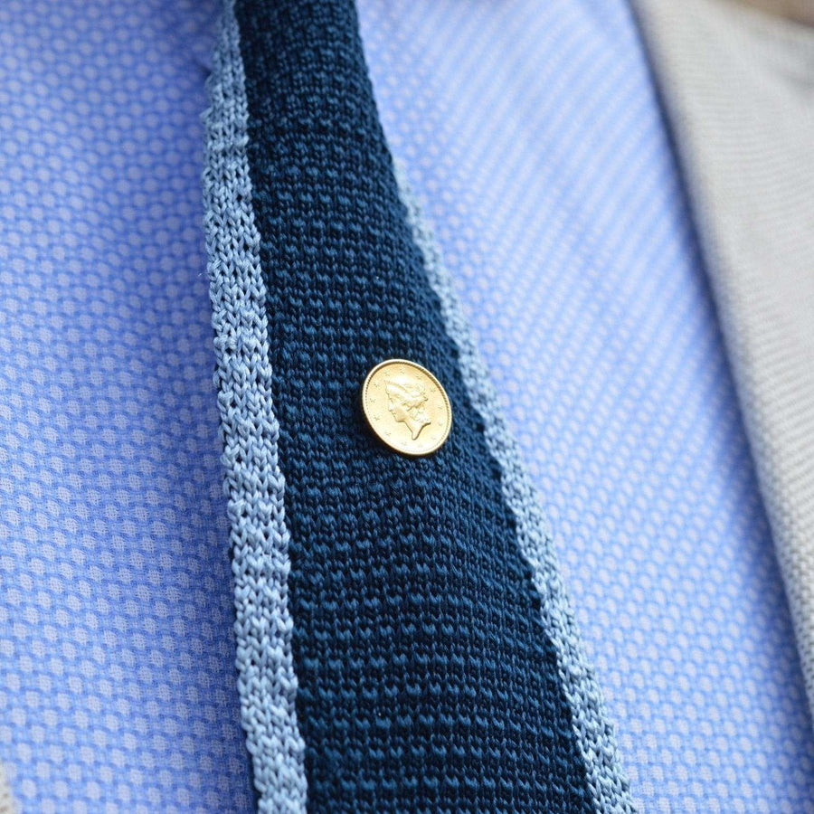 Amerikanische Gold $1 Liberty Head Krawattennadel aus dem 19. Jahrhundert auf einer stilvollen Krawatte, die Eleganz und historische Bedeutung zeigt.