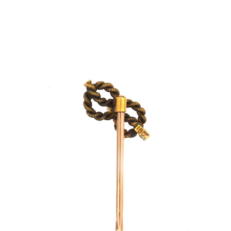 Edwardian 15ct gold lover's knot tie pin with natural pearl, symbolizing infinite love and crafted circa 1900.