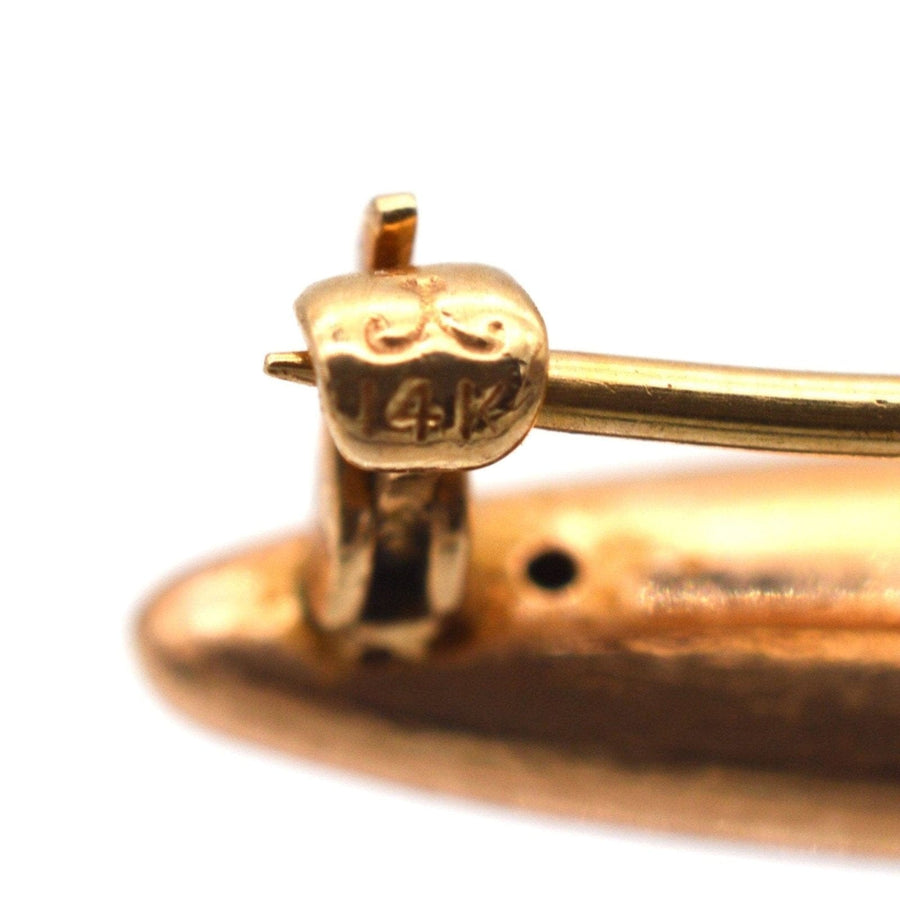 Nahaufnahme der 14-karätigen Goldpunze auf der Vintage-Brosche für ein kleines Mädchen, die die hochwertige Handwerkskunst und die komplizierten Designdetails hervorhebt.