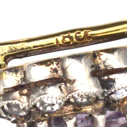 Nahaufnahme einer Art Deco Krawattennadel aus 18-karätigem Gold mit Amethyst und weißer Paste in Clusterform.
