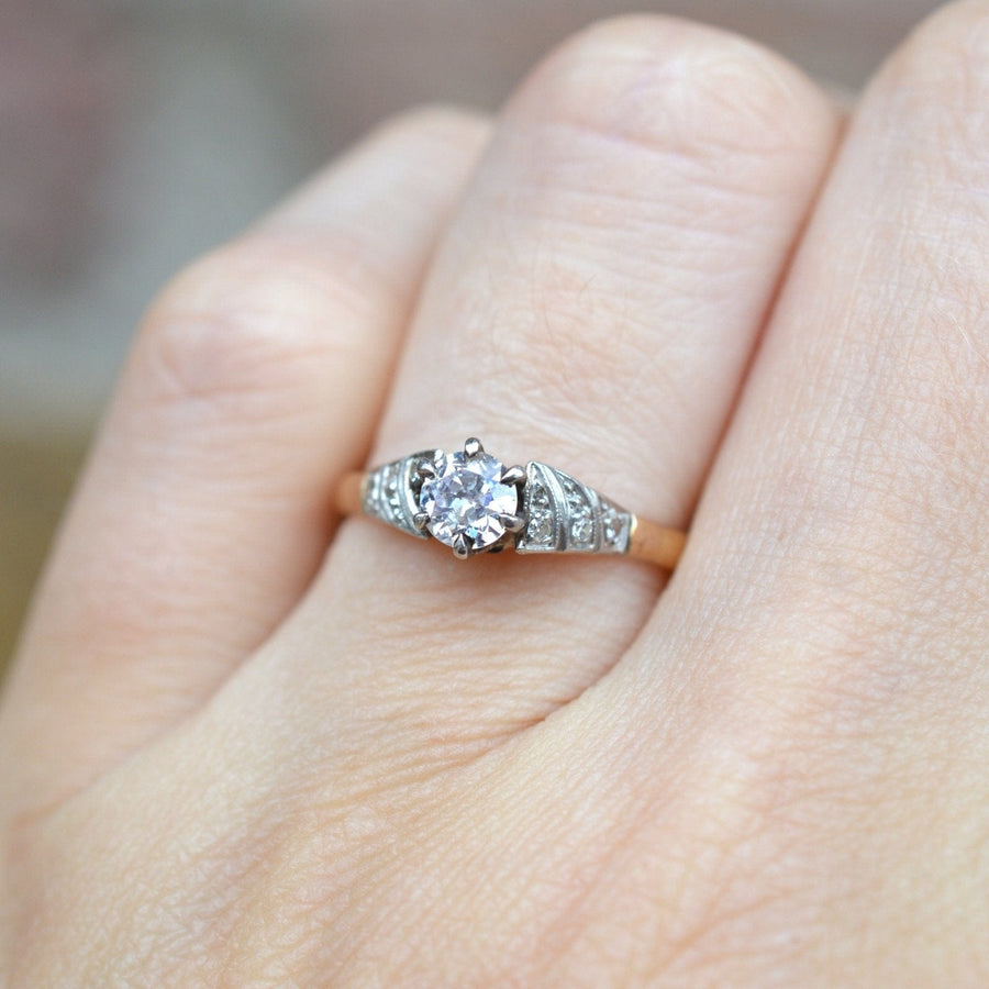 Solitärring aus 18-karätigem Gold im Art-Déco-Stil aus den 1920er Jahren mit einem funkelnden Diamanten in der Mitte und komplizierten seitlichen Verzierungen.