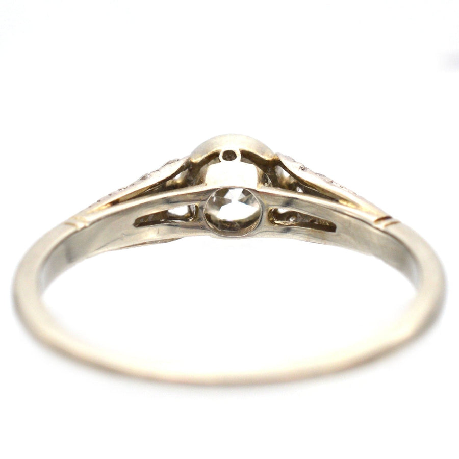 Solitärring aus 18-karätigem Gold und Diamanten im Art-Deco-Stil mit verzierten Schultern, der exquisite Handwerkskunst zeigt.