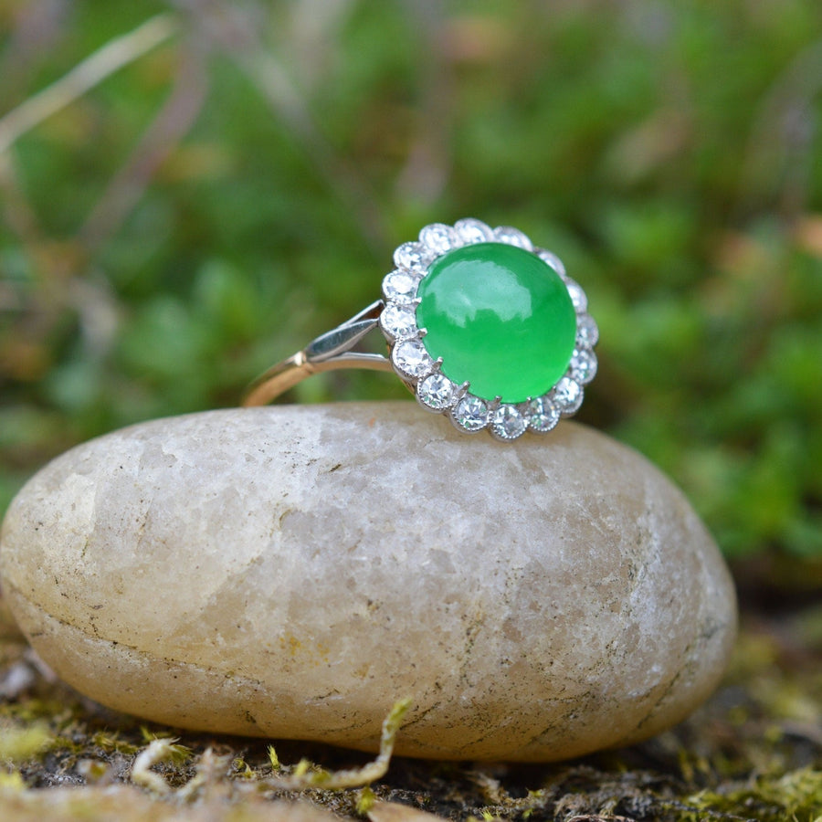 Art-Deco-Ring aus 18-karätigem Gold mit zertifiziertem Imperial-Jadeit und Diamantcluster auf einem glatten Steinhintergrund.