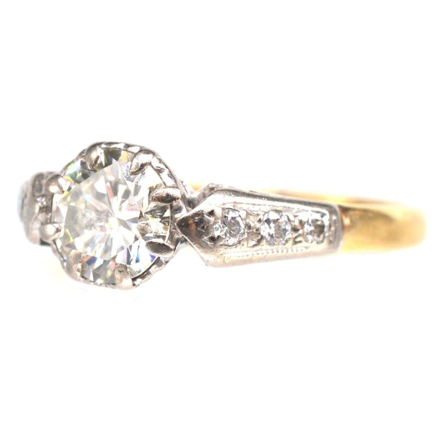 Solitärring aus 18-karätigem Gold und Platin mit Diamanten auf den Schultern und einem großen zentralen Diamanten.