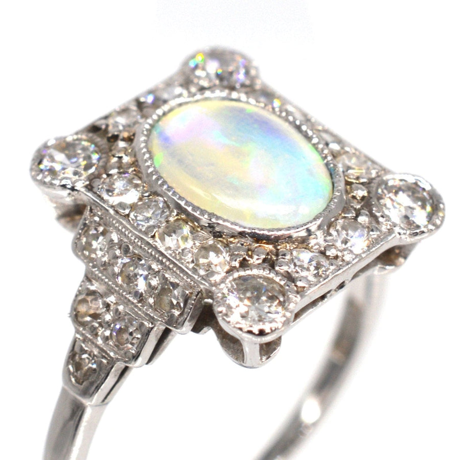 Art-Déco-Ring aus 18 Karat Gold und Platin mit einem farbenfrohen Opal, der von Diamanten umgeben ist und exquisite Handwerkskunst zeigt.