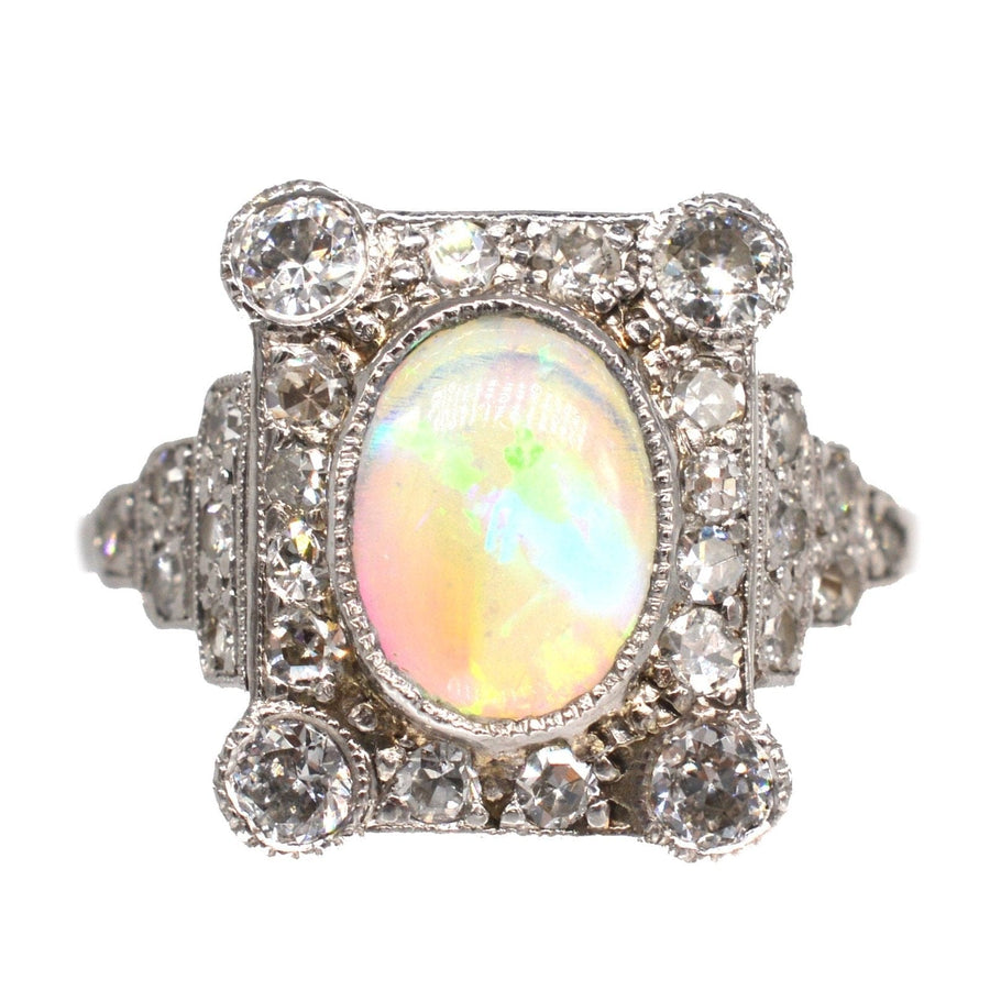 Ring aus 18 Karat Gold und Platin im Art-Déco-Stil mit einem ovalen Opal, der von Diamanten umgeben ist und exquisite Handwerkskunst zeigt.