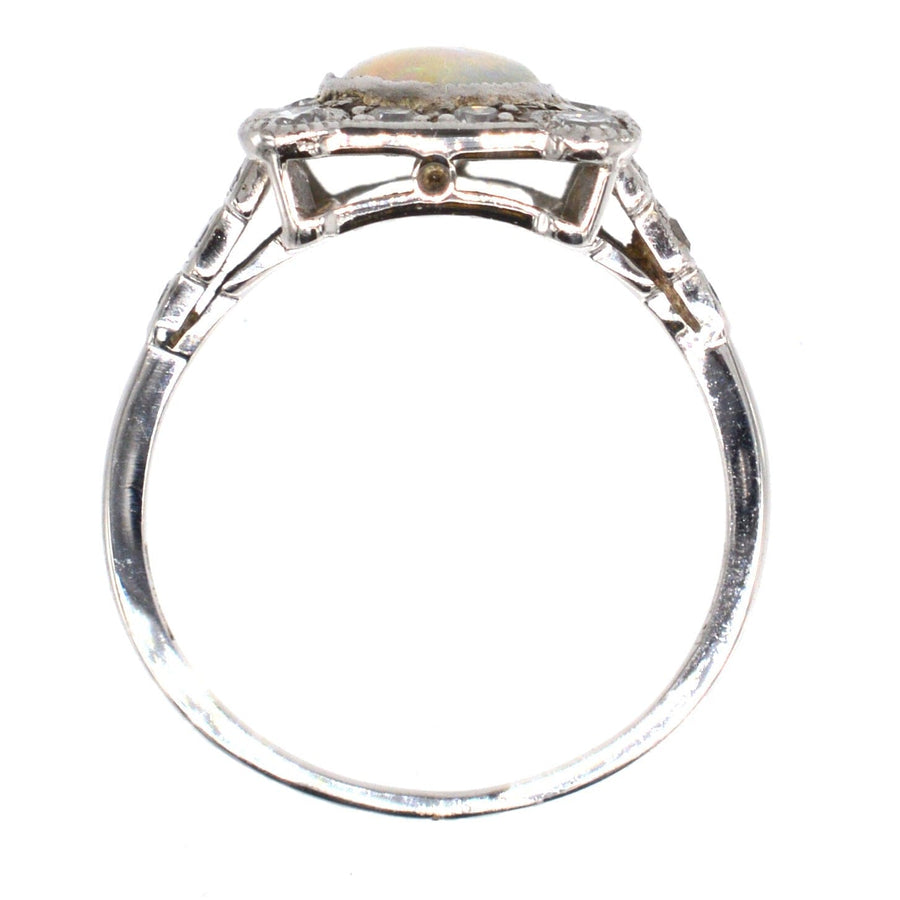 Art-Deco-Ring aus 18 Karat Gold und Platin mit einem Opal in der Mitte, umgeben von Diamanten.