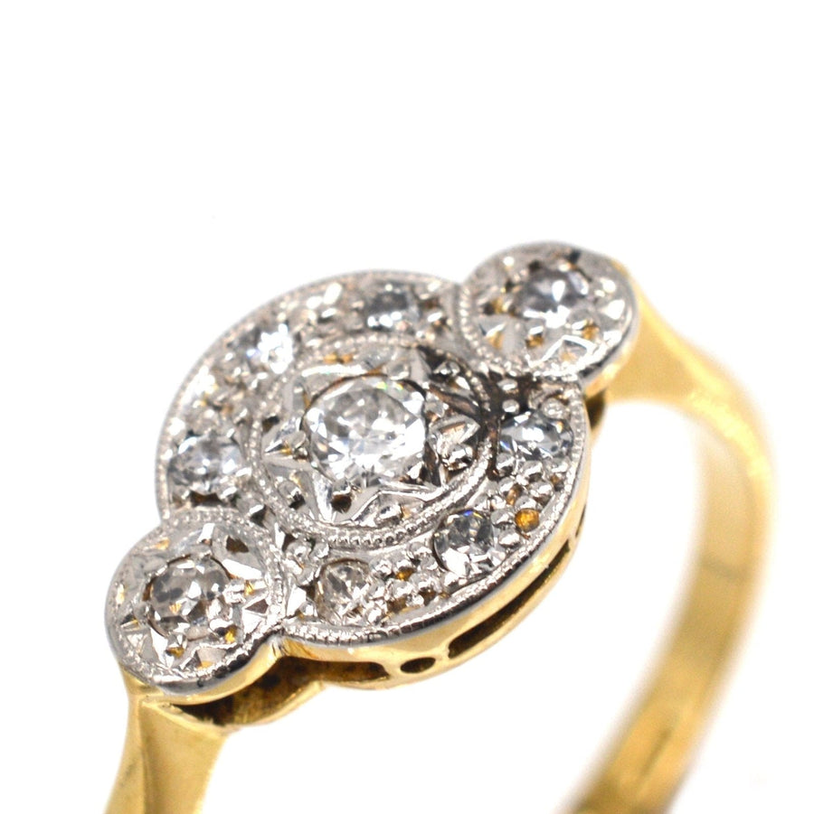 Art-Deco-Ring aus 18 Karat Gold und Platin mit drei Diamanten im Halo-Design und aufwändiger Verzierung.