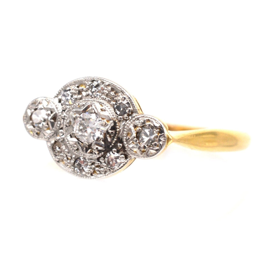 Art-Deco-Ring aus 18 Karat Gold und Platin mit drei Steinen und funkelnden Diamanten in Halo-Form.