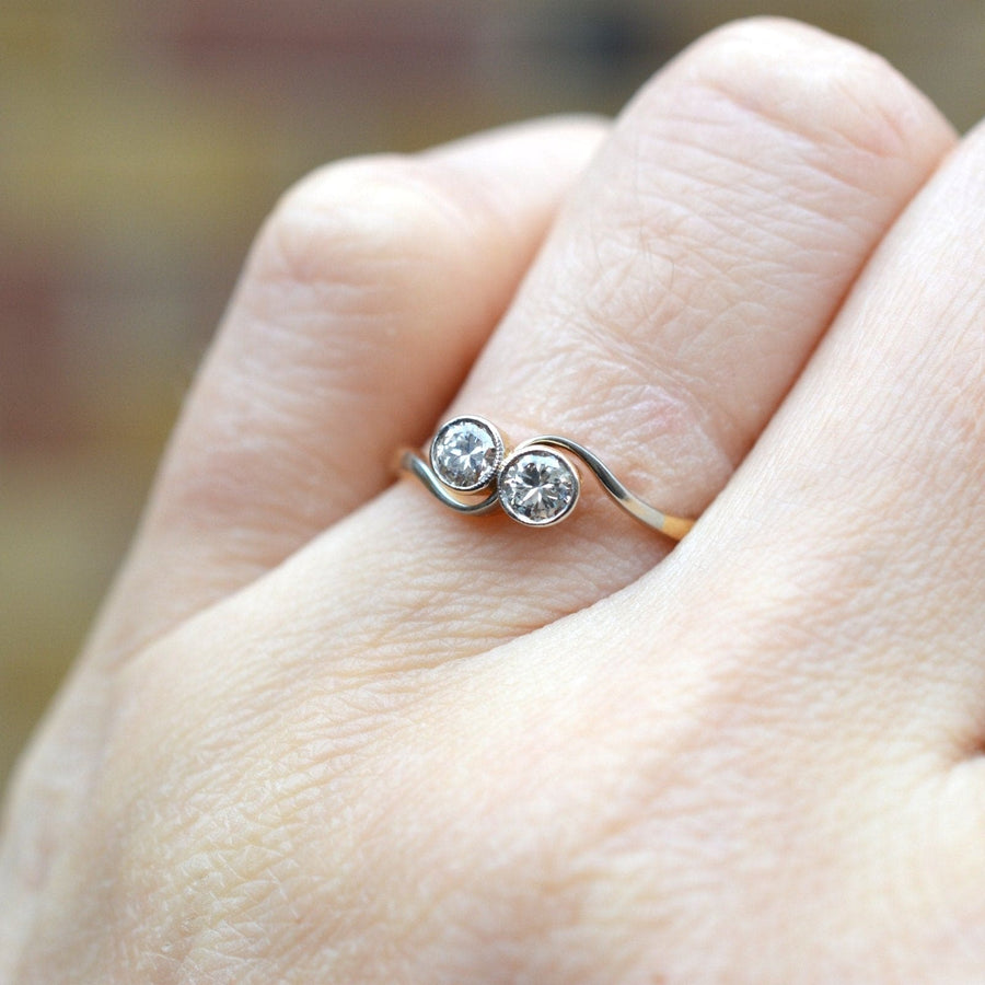 Art-Deco-Ring aus 18-karätigem Gold und Platin "Toi et Moi" mit gekreuzten Diamanten an der Hand, der Liebe und Einheit symbolisiert.