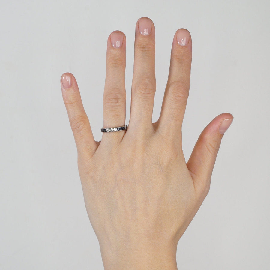 Art Deco 18ct Weißgold Saphir und Diamant Ewigkeitsring präsentiert auf einer Hand.