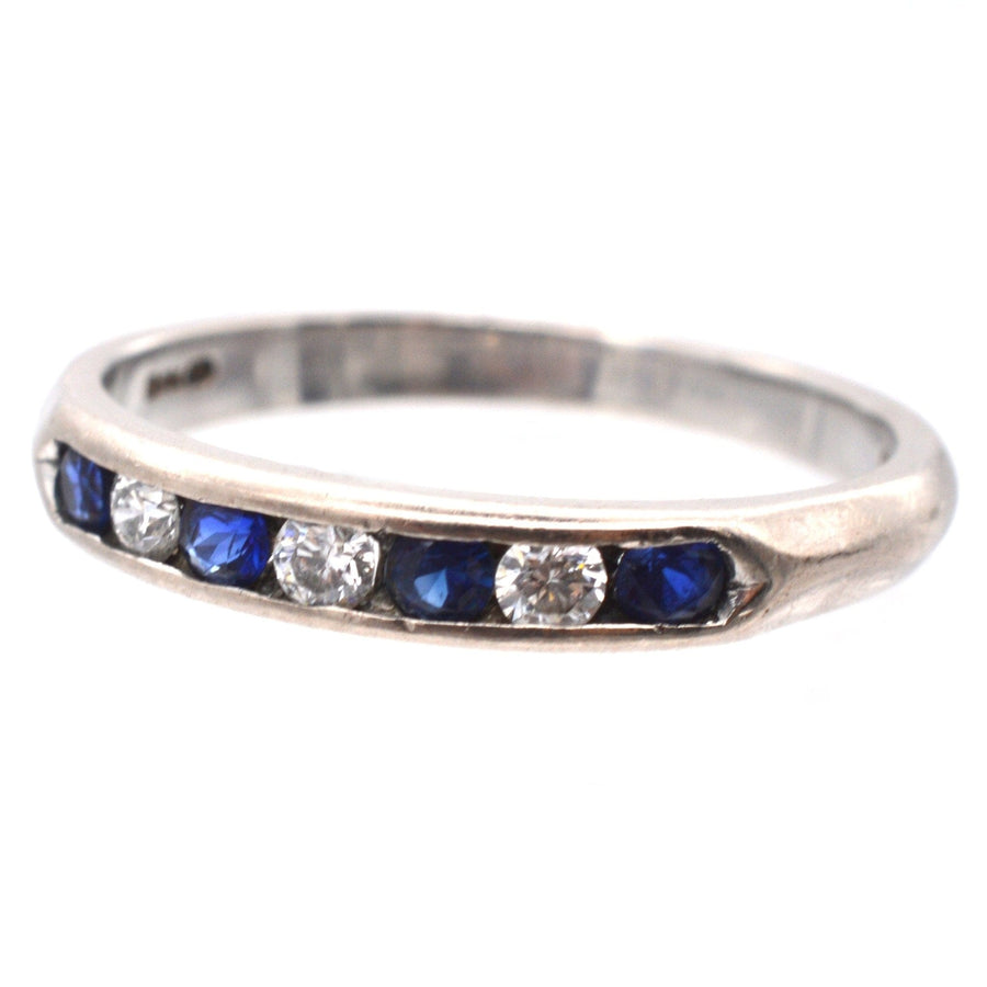 Halber Ewigkeitsring aus 18 Karat Weißgold mit blauen Saphiren und Diamanten in einer Kanalfassung.
