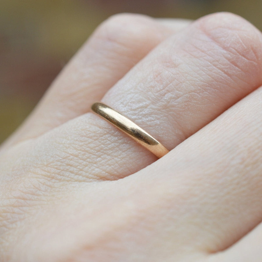Art Deco 1937 9ct gold wedding ring worn on a hand, featuring a simple, thin shank design.