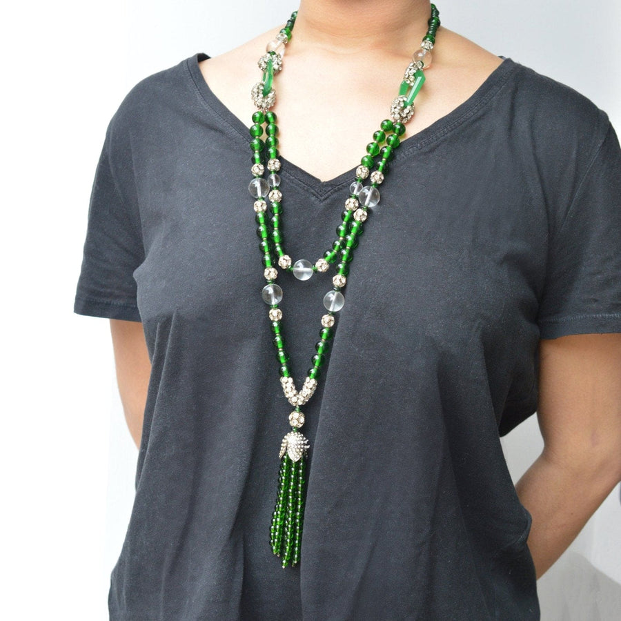 Art Deco lange grüne Perlenkette mit Kristallakzenten, getragen an einem Modell, das den eleganten Vintage-Schmuckstil präsentiert.