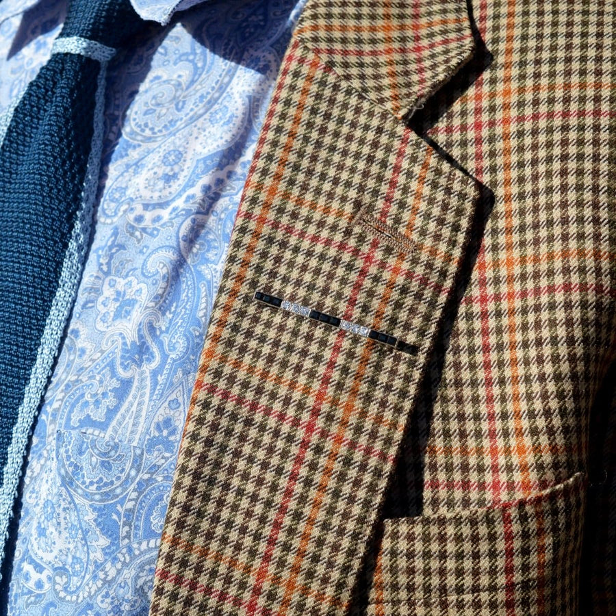 Nahaufnahme eines gemusterten Blazers mit Krawatte, der ein stilvolles Reversdetail aufweist.