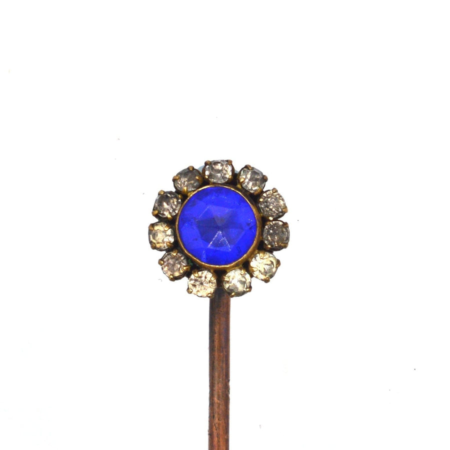 Art Deco Krawattennadel mit einem kobaltblauen, geschliffenen Glas in der Mitte, umgeben von weißen Steinen.